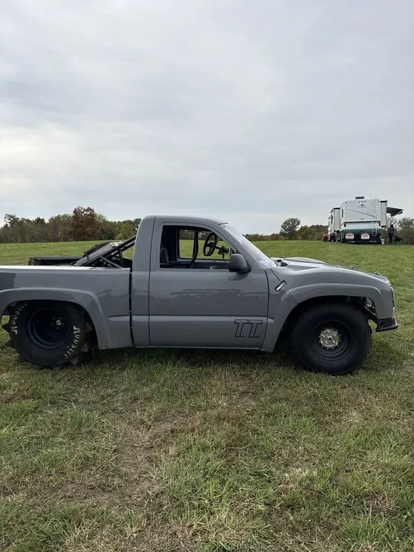 Top Gun side profile: gray Chevy single-cab with TT on the door and rear paddle tires