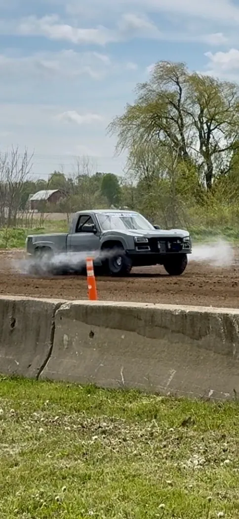 Top Gun on a dirt track with tire smoke rolling off the rear