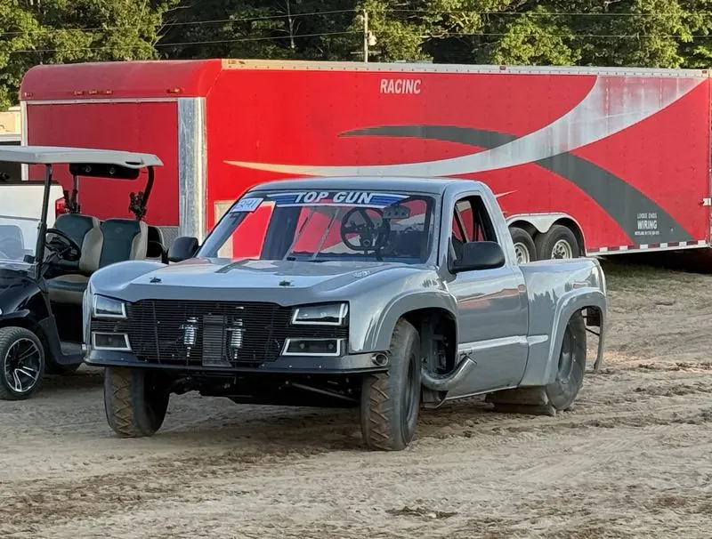 Top Gun parked at the track in front of a red trailer, front three-quarter view